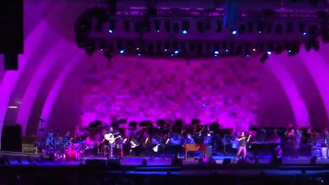 Live orchestra and rock band performing “Dream On” under purple stage lighting at the Hollywood Bowl
